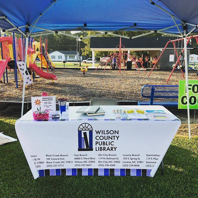 A table at an outside event bearing the Wilson County Public Library logo